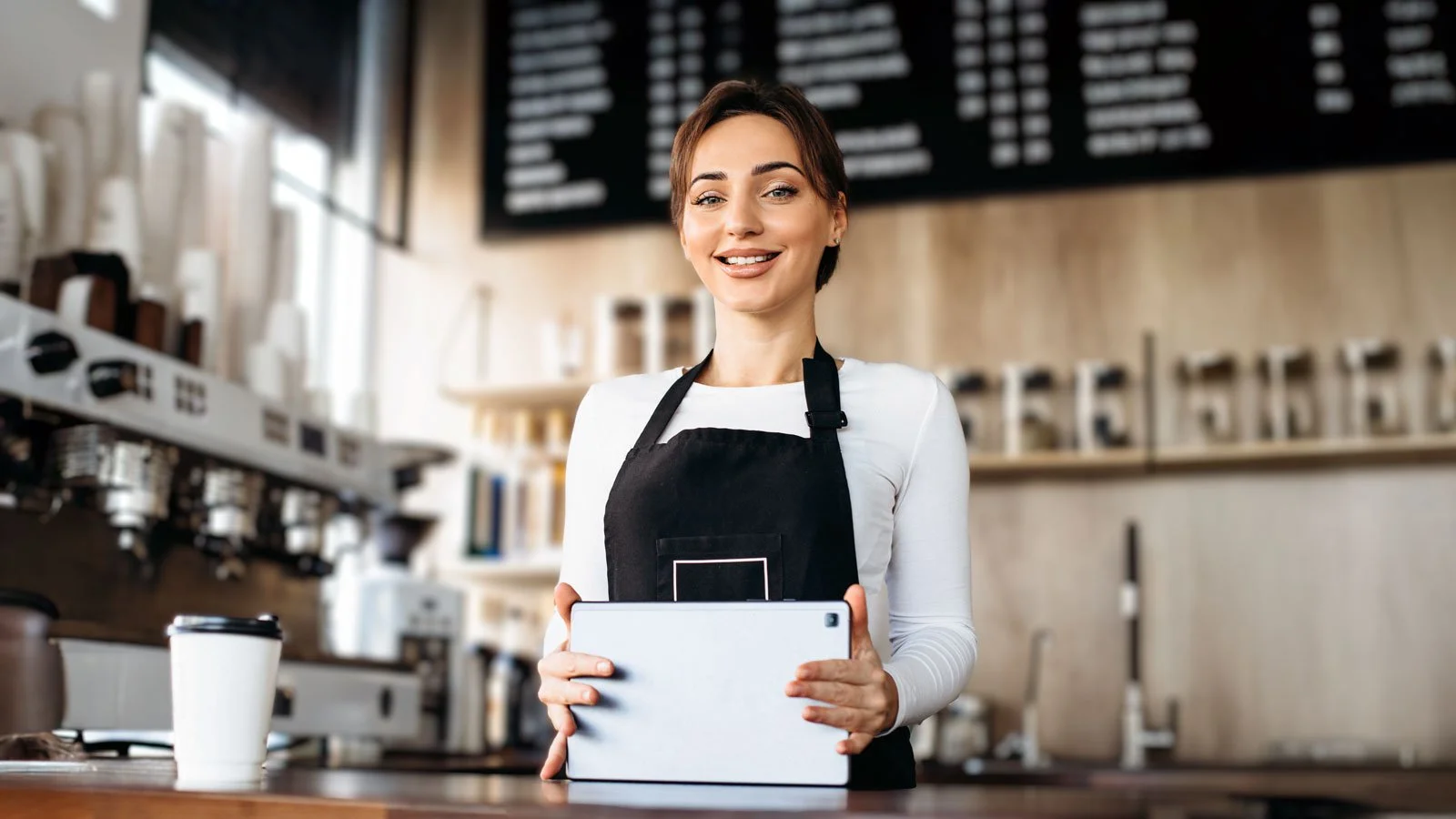Female barista with tablet making order in a coffee shop