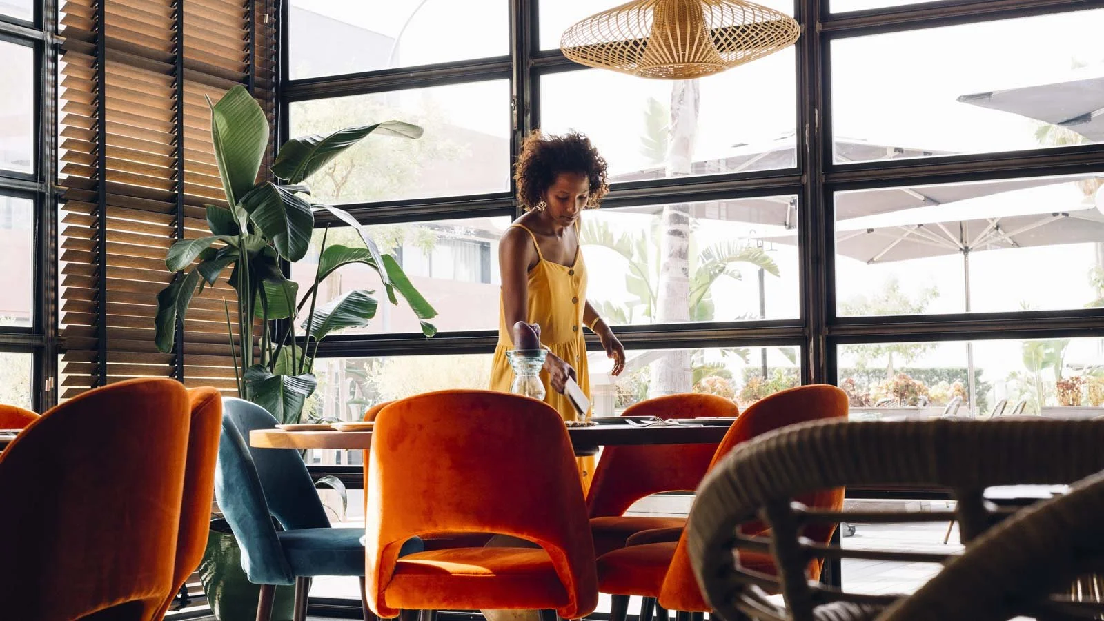 Young woman arranging the table in the restaurant