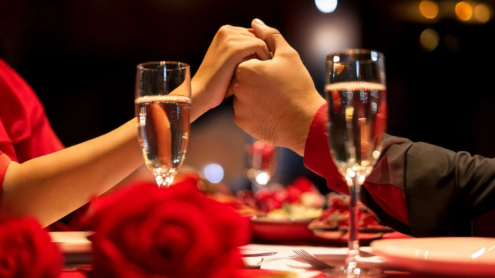 A couple holding hands at a Valentine's Day dinner